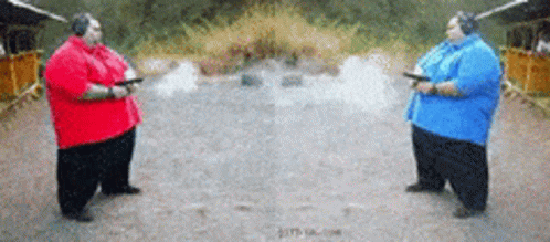 Two Fat Men Holding Guns In A Shooting Range GIF