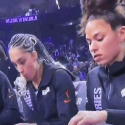 Two Female Basketball Players Sitting At Table In Front Of Crowd GIF