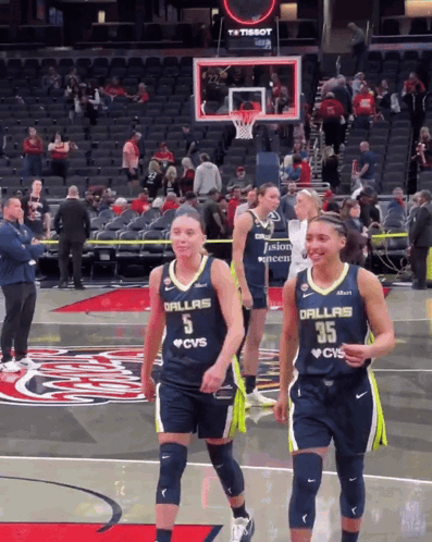 Two Female Basketball Players Wearing Dallas Jerseys Are Walking On The Court GIF