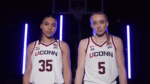 Two Female Basketball Players Wearing Uconn Uniforms Stand Next To Each Other GIF