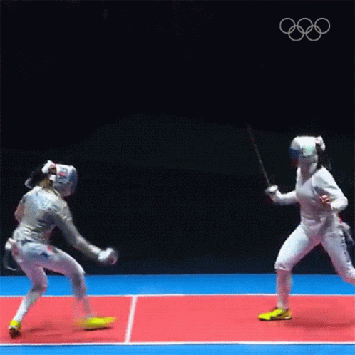 Two Female Fencers Are Fighting Each Other On A Court . GIF