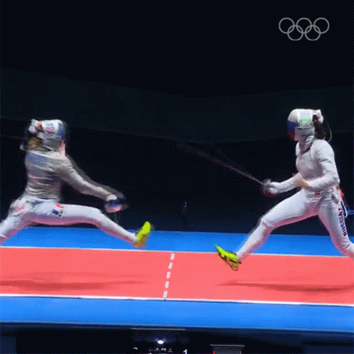 Two Female Fencers Are Fighting On A Red And Blue Court With The Olympics Logo In The Background GIF