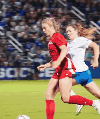 Two Female Soccer Players With Socce Sign