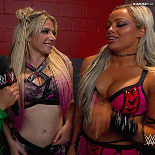 Two Female Wrestlers Are Standing Next To Each Other And One Has A Wwe Logo On Her Chest GIF