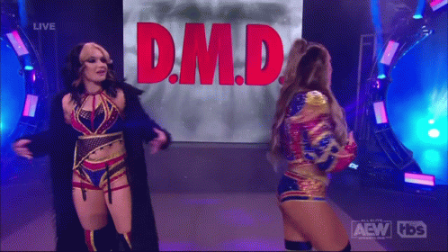 Two Female Wrestlers in Front of Screen Saying D.M.D