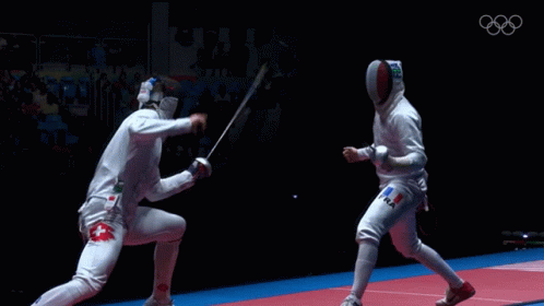 Two Fencers Are Fighting Each Other With The Olympics Logo In The Background GIF
