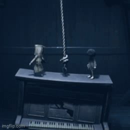 Two Figurines Standing on Piano in Dark Room