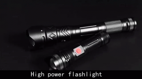 Two Flashlights Are Sitting On A Black Surface . GIF