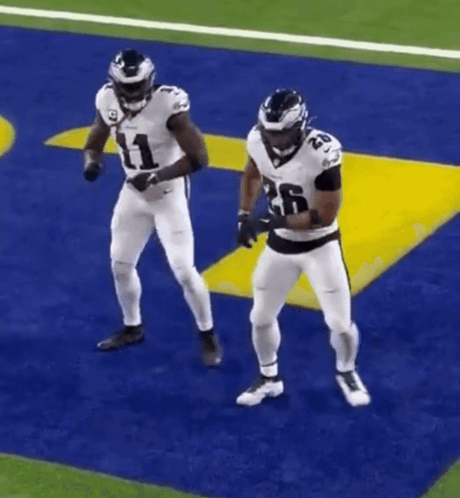 Two Football Players Are Dancing On A Field And One Has The Number 26 On His Jersey GIF