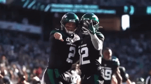 Two Football Players Are Hugging Each Other And One Has The Number 2 On His Jersey GIF