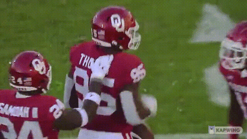 Two Football Players Are Hugging Each Other On A Field And One Of Them Has The Number 28 On His Jersey GIF