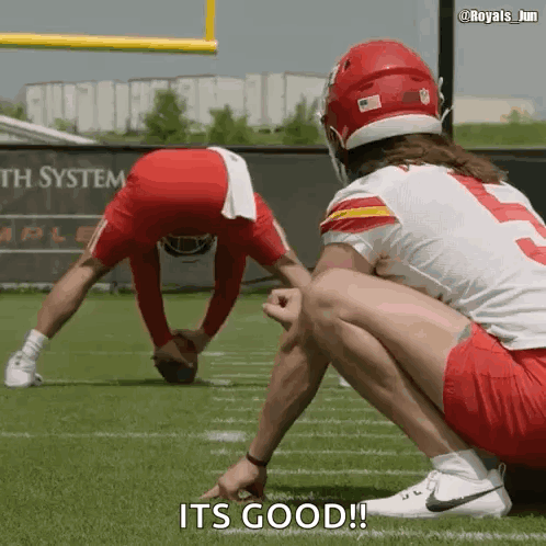 two football players are squatting on the field and one of them says it 's good