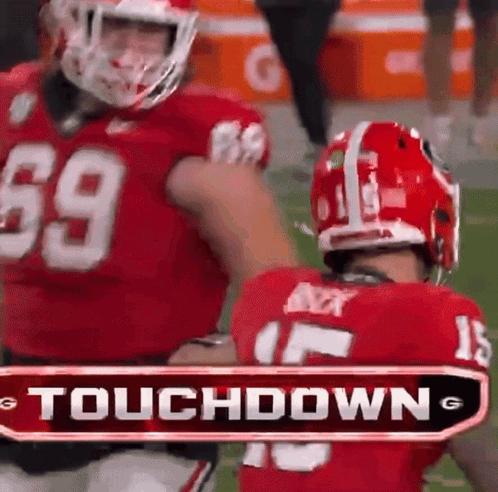 Two Football Players Are Standing Next To Each Other With A Touchdown Sign In The Background GIF