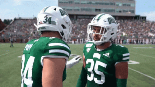 Two Football Players in Green and White Uniforms Numbers 34 and 35
