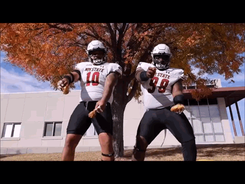 Two Football Players In My State Jerseys Dancing In Front Of Tree GIF