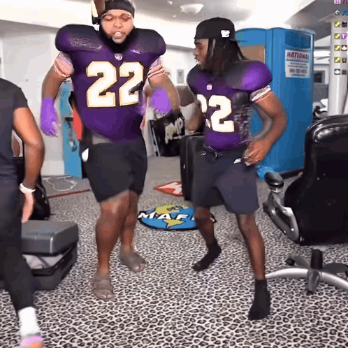 two football players in purple uniforms with the number 22 on them