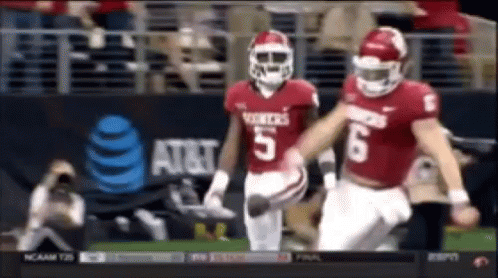Two Football Players Number 5 and 6 Running