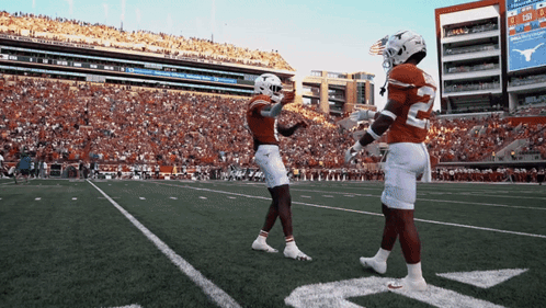 two football players on a field with a scoreboard behind them that says texas tech
