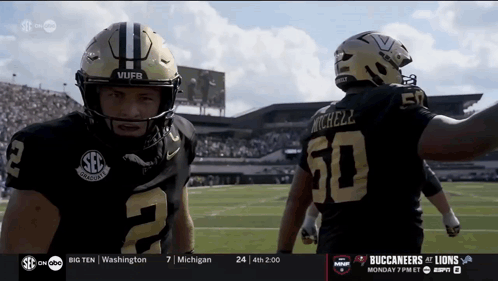 Two Football Players One Of Whom Has The Number 50 On The Back Of His Jersey GIF