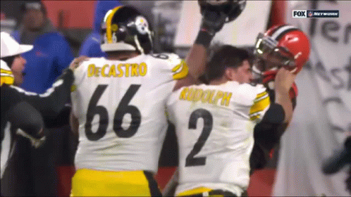 Two Football Players One Of Whom Has The Number 66 On Their Jersey GIF
