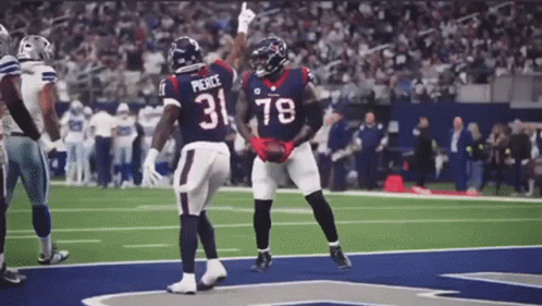 Two Football Players Wearing Jerseys With The Number 31 And 78 Are Celebrating On The Field . GIF