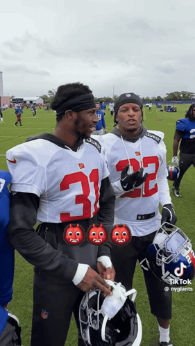 Two Football Players Wearing Jerseys With The Number 32 GIF