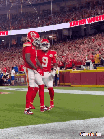 Two Football Players With Xavier Worth Banner GIF