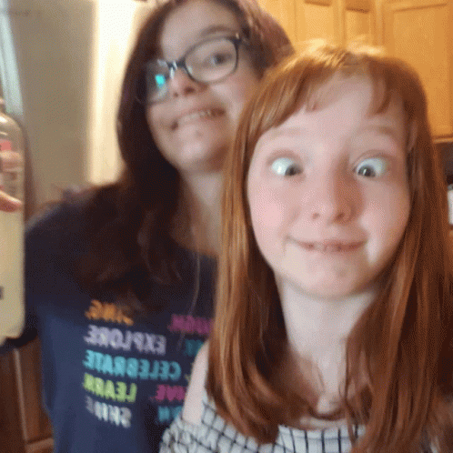 Two Girls Are Posing For A Picture And One Has A Shirt That Says Explore GIF