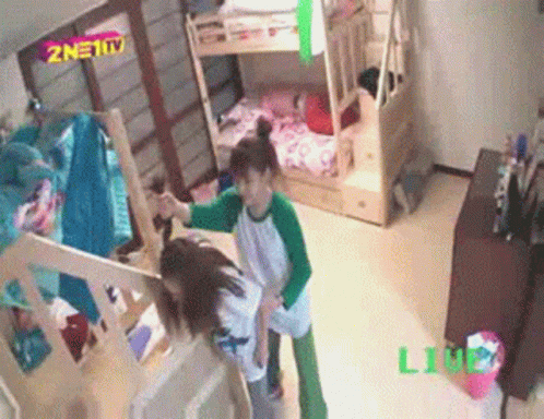 Two Girls Are Standing In A Room With Bunk Beds And A Sign That Says Znet Tv GIF