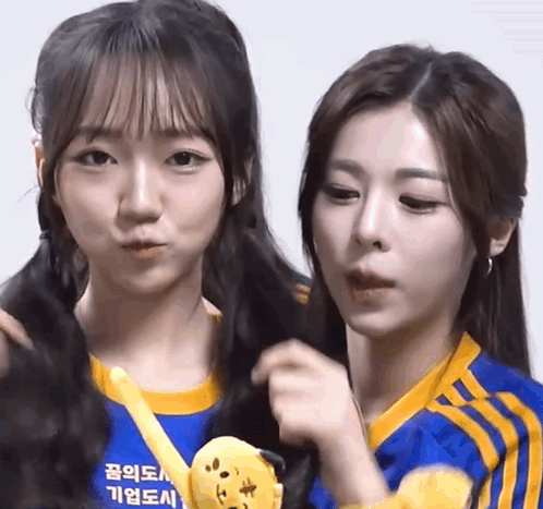 Two Girls Are Standing Next To Each Other With One Wearing A Blue Shirt That Says ' Seoul ' On It GIF