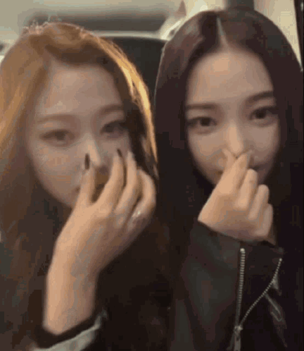 Two Girls Covering Noses