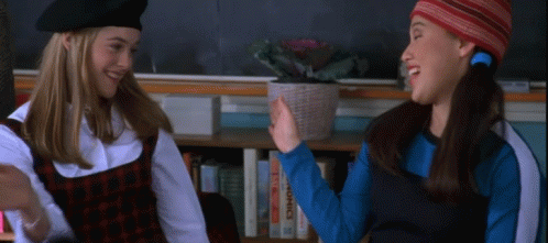 Two Girls High Five by Bookshelf