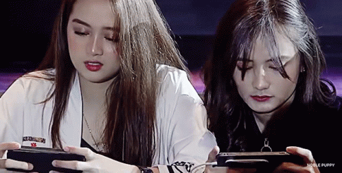 Two Girls Playing Game on Phones With Noble Puppy