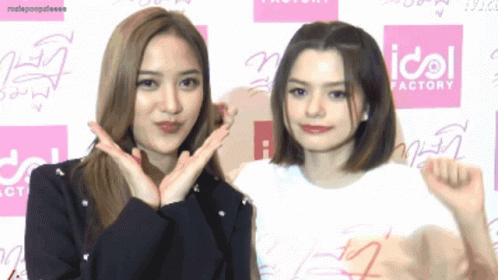 Two Girls Posing in Front of Idol Factory Sign