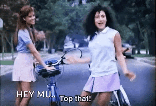 Two Girls Riding Bikes Saying Hey Mu Top That