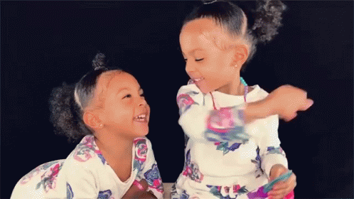 Two Girls Sitting Next to Each Other