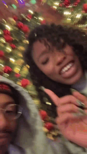 Two Girls Smiling Next to Christmas Tree