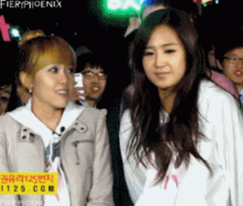 Two Girls Standing Beside Fieryphoenix Sign