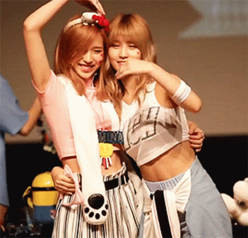 Two Girls Standing Next To Each Other One With Mina Necklace GIF