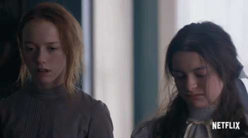 Two Girls Standing Next To Each Other With A Netflix Logo On The Bottom Right GIF