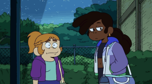 Two Girls Standing Together, One in Purple Jacket