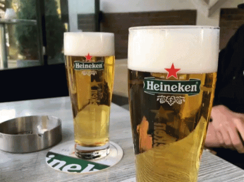 Two Glasses Of Heineken Beer Next To Ashtray GIF