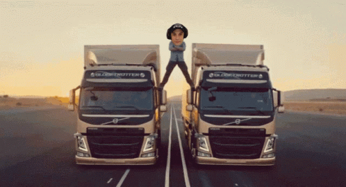 Two Globetrotter Trucks Are On The Road With A Man Standing On Top Of One GIF