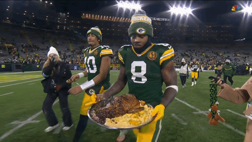 Two Green Bay Packers Players Carrying Plate of Food