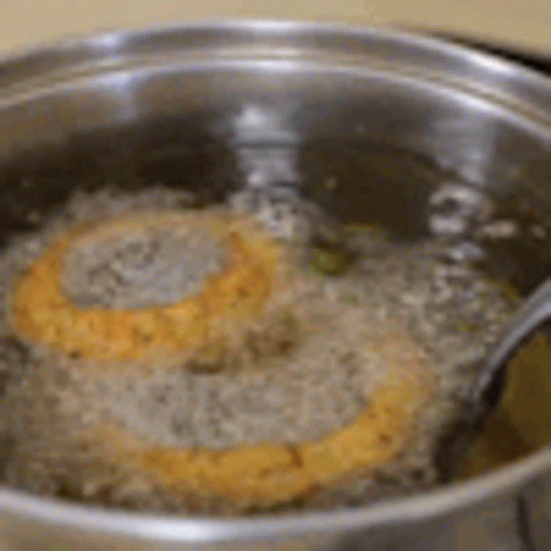 Two Hamburger Patties Cooking in Oil with Fork