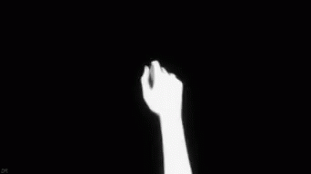 Two Hands Holding Each Other in the Dark