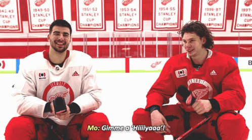 Two Hockey Players Are Sitting On The Ice And One Of Them Is Saying Mo Gimme A Hillyaaa GIF