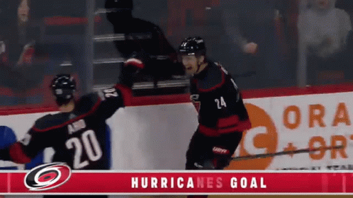 Two Hockey Players Celebrate A Hurricanes Goal In Front Of A Gatorade Ad GIF