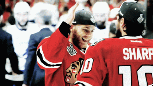 Two Hockey Players High Five Each Other With One Wearing The Number 10 And The Other Wearing The Number 16 GIF