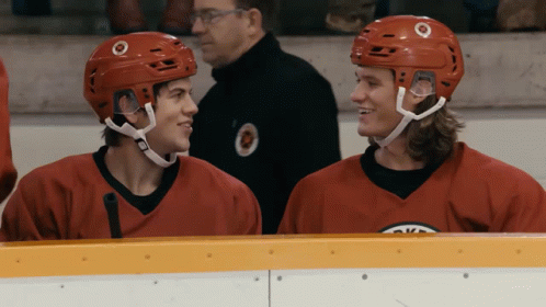 Two Hockey Players in Red Jerseys Sitting